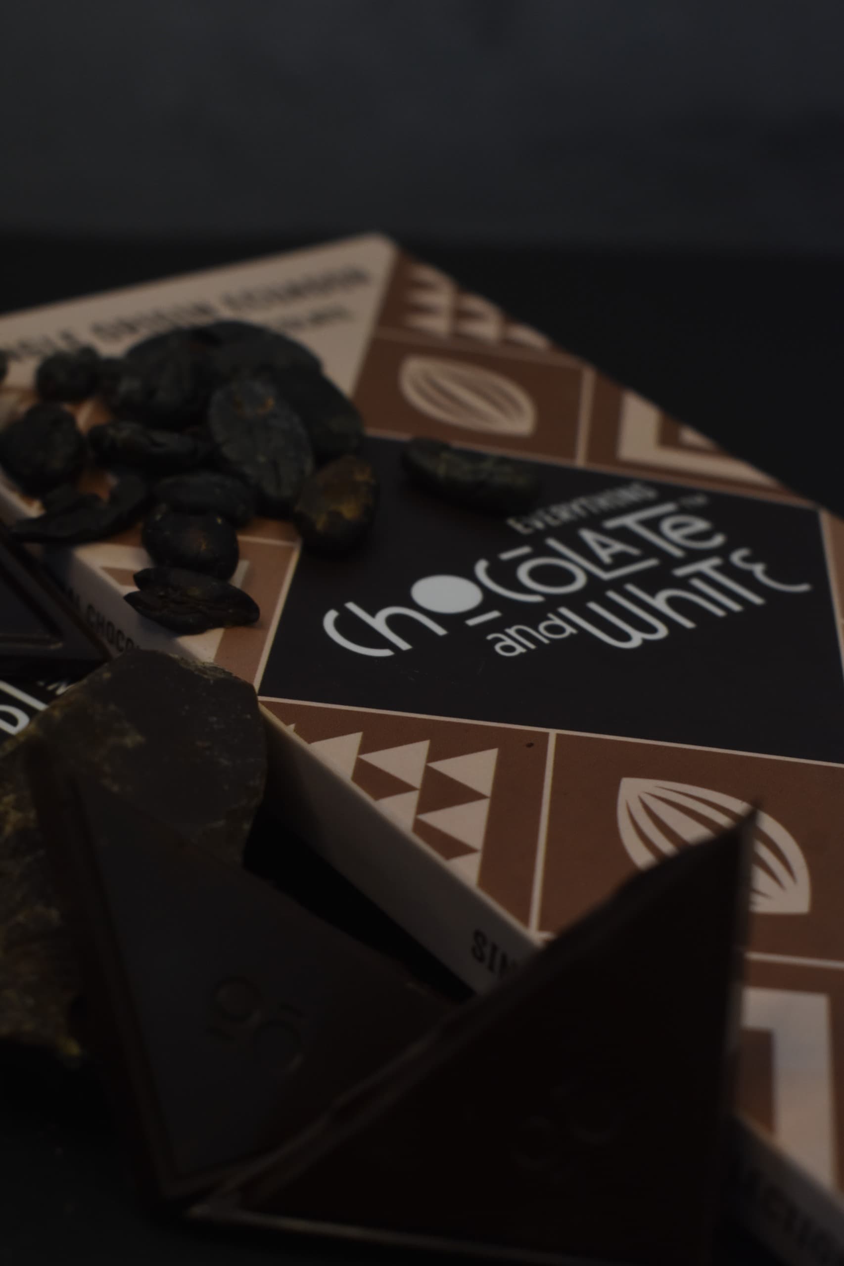 Chocolate and White artisanal chocolate surrounded by cocoa ingredients